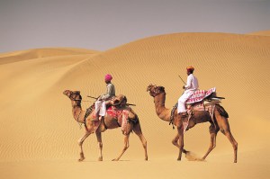 Two men on camelback in desert, Jaiselmer, India 546003
