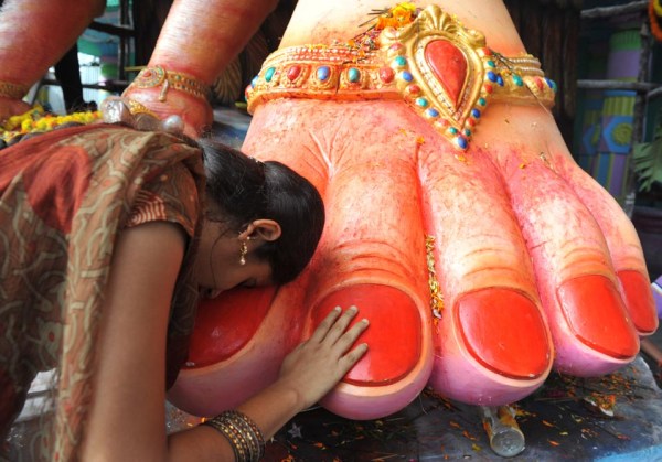 Indian devotees touches the foot while praying and seek blessings at a 52 foot tall idol of the elephant-headed Hindu god Lord Ganesh during the 'Ganesh Chaturthi' Hindu festival in Hyderabad on September 2, 2011. Hindu devotees bring home idols of Lord Ganesha during the 'Ganesh Chaturthi' in order to invoke his blessings for wisdom and prosperity, during the eleven day long festival which culminates with the immersion of the idols in the Arabian Sea.   AFP PHOTO / Noah SEELAM (Photo credit should read NOAH SEELAM/AFP/Getty Images)